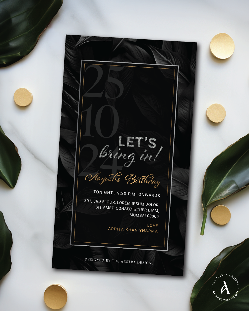 Moody black and gold birthday invitation surrounded by tropical leaves and gold confetti.
