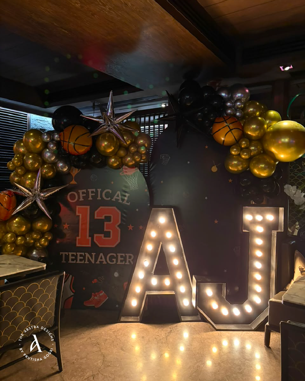 AJ birthday marquee with gold and black balloon decor
